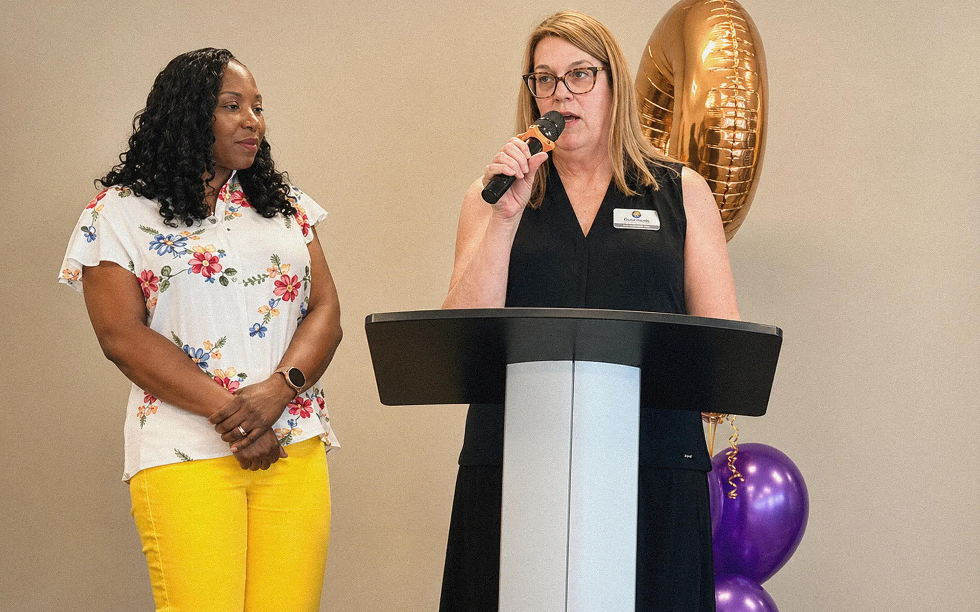 Two speakers at a Good Hands event podium