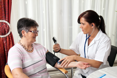 nruse measuring patient blood pressure