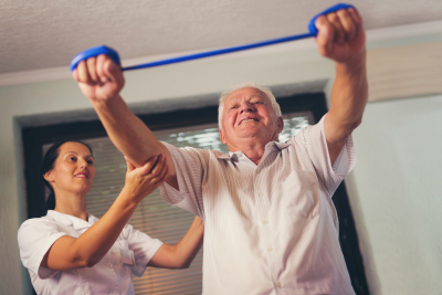 caregiver guiding senior men doing exercise