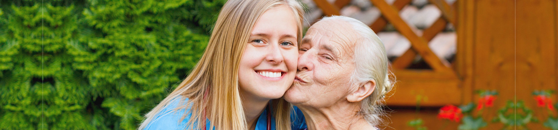 senior woman kissing her caregiver